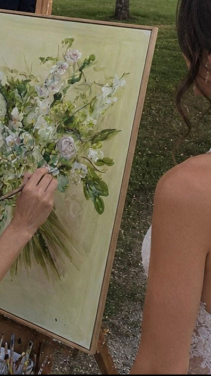 Woman painting a floral scene with a bride and groom in the background